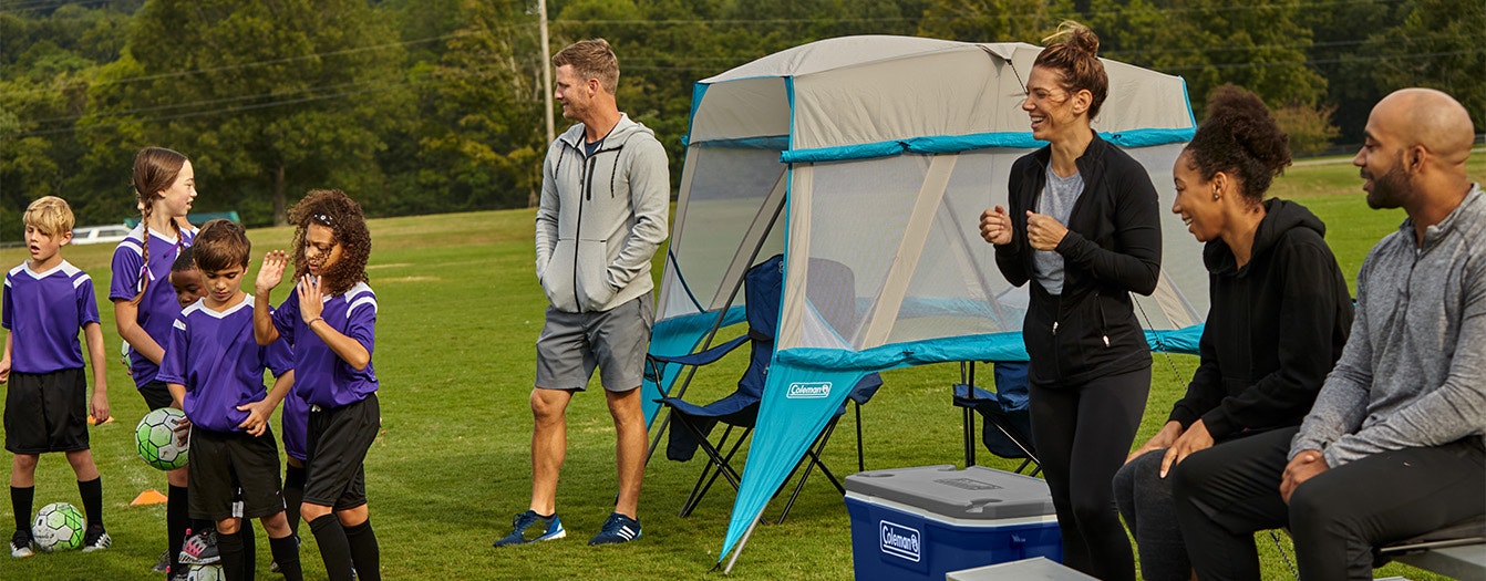 Sideline Sports Essentials Parents and kids at a youth soccer game using Coleman gear