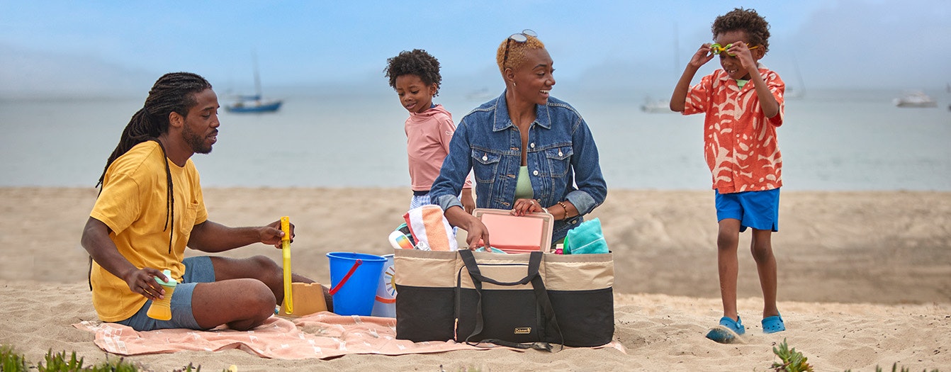 a family sitting on a blanket at the beach